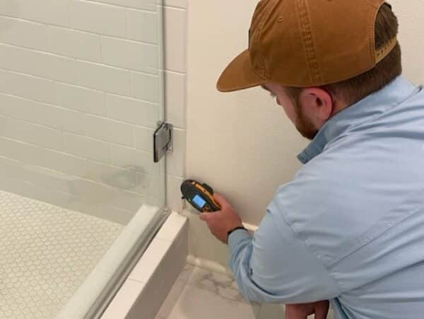 Home inspector performing indoor air quality tests using a moisture meter